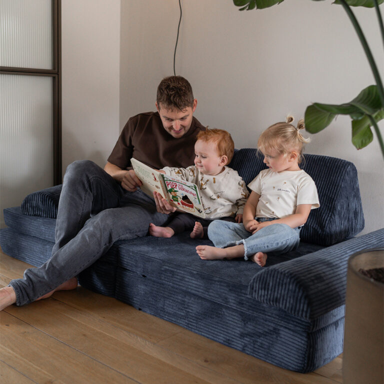 Gemeinsam ein Buch lesen auf dem Jindl Cord Spielsofa in Marineblau