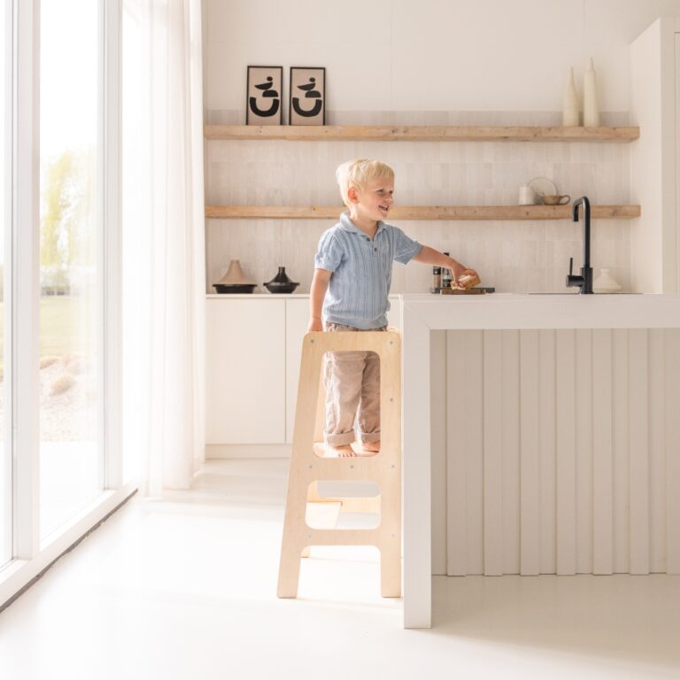 Kind auf dem Jindl Standard-Lernturm an der Küchenarbeitsplatte