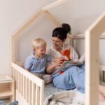 Kleinkind und Mutter im Kinderbett für Kleinkinder - Hausbett lachen