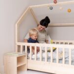 Gemeinsam im Kinderzimmer mit Nachttisch und Hausbett lesen