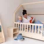 Gemeinsam im Kinderzimmer mit Nachttisch und Hausbett lesen