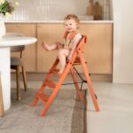 Kind im rosa Hochstuhl mit Gurt und Kissen KAOS