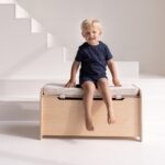 Sitzkissen für Spielzeugkiste - Aufbewahrungskiste beige sitzend und lachend