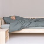 Bettdecke über Baby im Kinderbett, Augen geschlossen