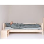 Kinderbett mit schlafendem Baby im Bett unter Decken