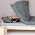 In einem Kinderbett mit fliegender Bettdecke unterbringen