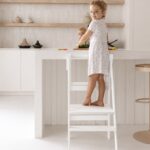 Montessori Lernturm klappbar & verstellbar Jindl Komplett weiß - stehendes Mädchen darauf