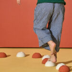 Balancieren auf einer MODU Foam Ball Hälfte in Sand Grey, Honey Yellow und Burnt Orange