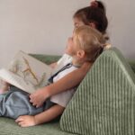 Detail der Rückenlehne des olivgrünen Jindl Cord Spielsofas beim gemeinsamen Lesen
